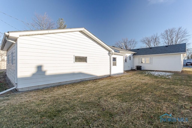 rear view of property with a yard and central AC