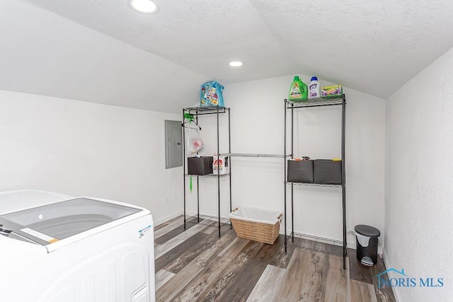 laundry area featuring hardwood / wood-style flooring, washing machine and dryer, a textured ceiling, and electric panel