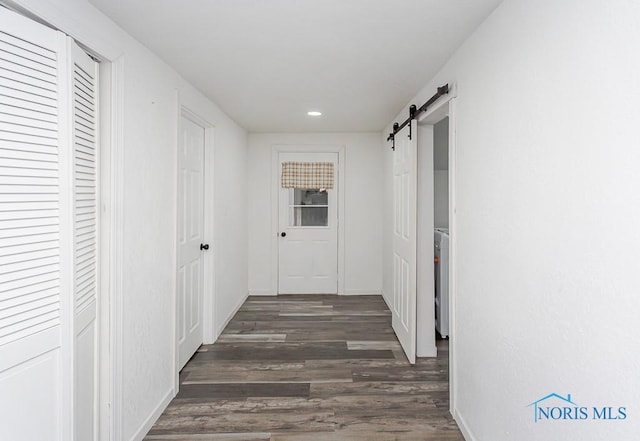 hallway featuring dark hardwood / wood-style floors and a barn door