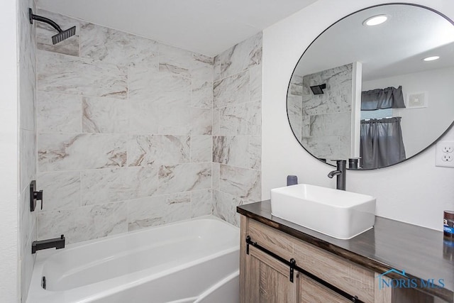 bathroom with tiled shower / bath and vanity