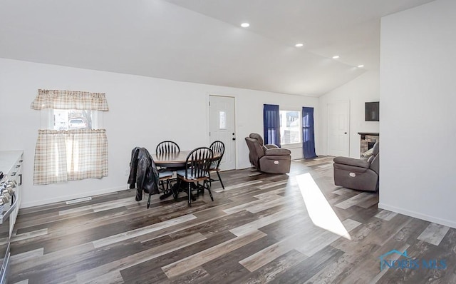 dining area with dark wood-type flooring and high vaulted ceiling