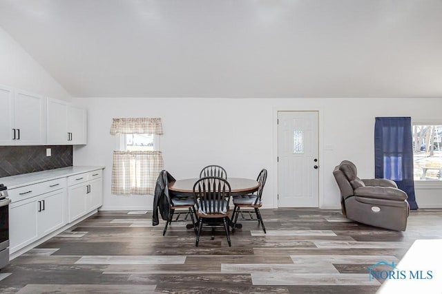 dining room with lofted ceiling and dark wood-type flooring