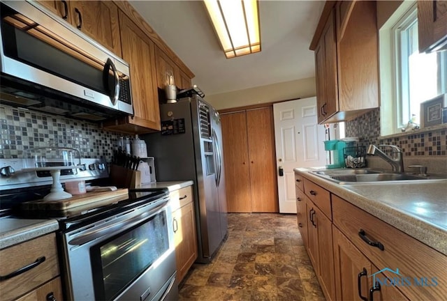 kitchen with sink, appliances with stainless steel finishes, and tasteful backsplash