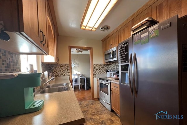 kitchen featuring ceiling fan, sink, appliances with stainless steel finishes, and tasteful backsplash