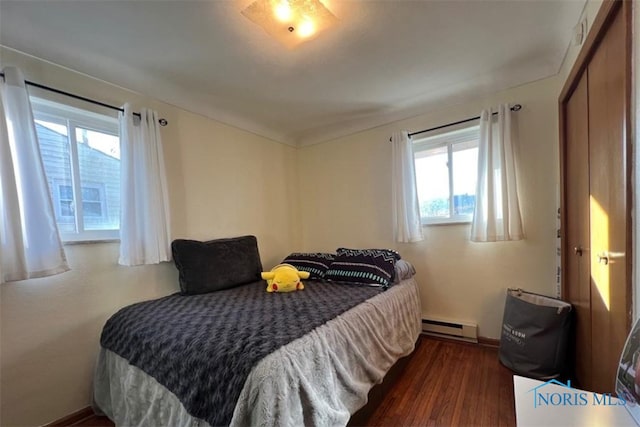 bedroom with baseboard heating and dark hardwood / wood-style flooring