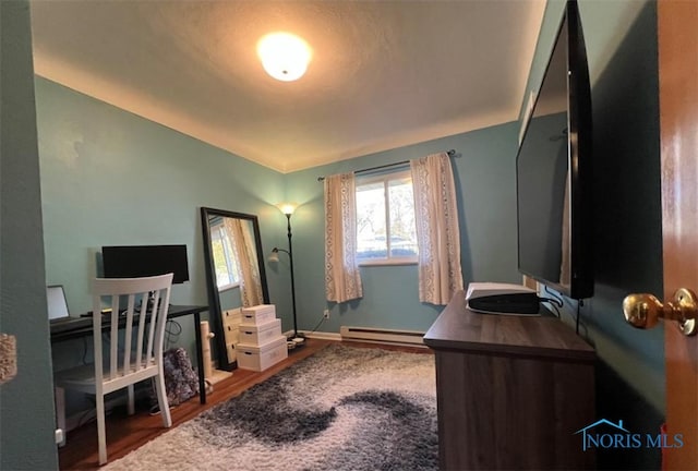 home office featuring a baseboard heating unit and hardwood / wood-style floors