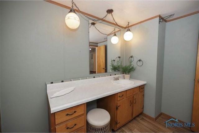 bathroom featuring crown molding, vanity, and hardwood / wood-style flooring