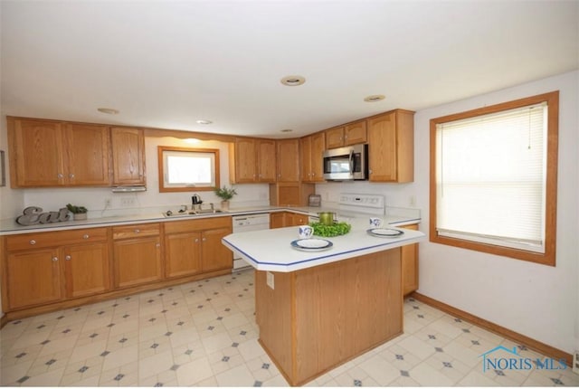 kitchen featuring sink, white electric range oven, a healthy amount of sunlight, and a kitchen island