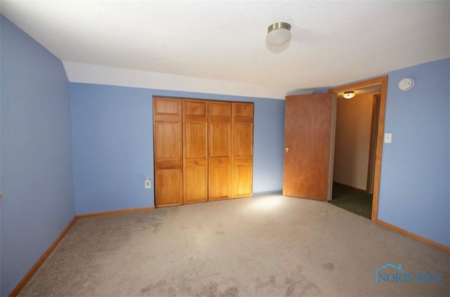 unfurnished bedroom with light carpet and a closet