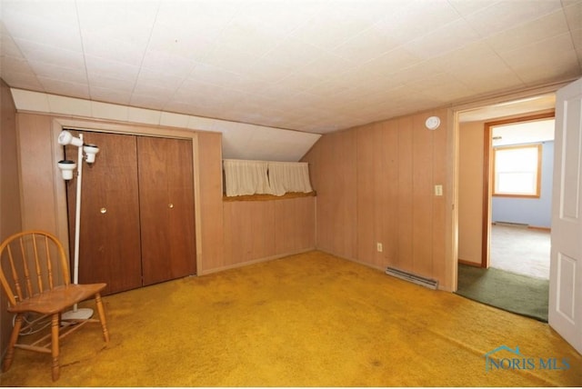 interior space with wooden walls, light colored carpet, and a baseboard radiator