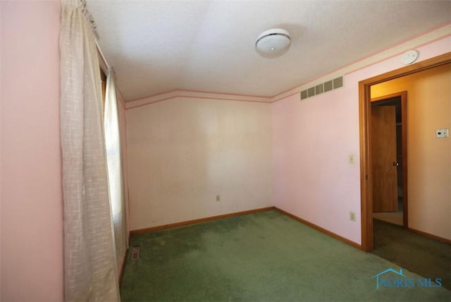 carpeted empty room with crown molding and vaulted ceiling