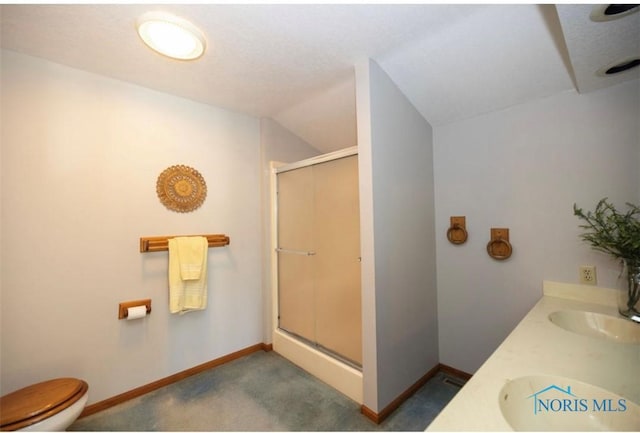 bathroom featuring vanity, toilet, and a shower with door