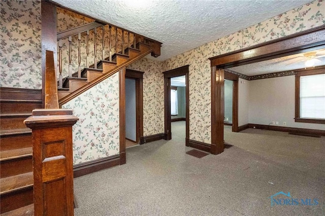 interior space featuring a textured ceiling and carpet flooring