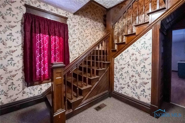 stairway featuring carpet