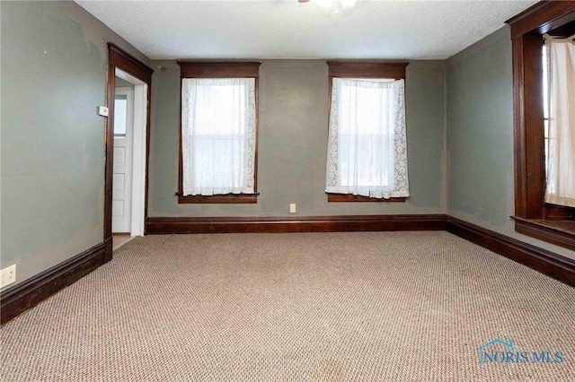 unfurnished room featuring a textured ceiling, plenty of natural light, and carpet floors