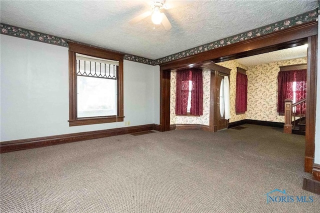 carpeted empty room featuring a textured ceiling and ceiling fan