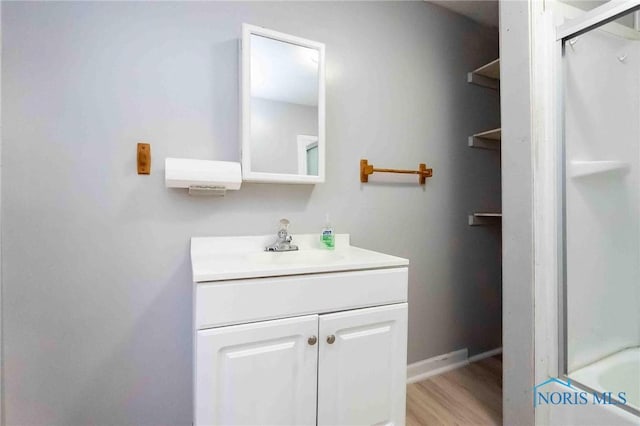 bathroom with bathtub / shower combination, vanity, and hardwood / wood-style flooring