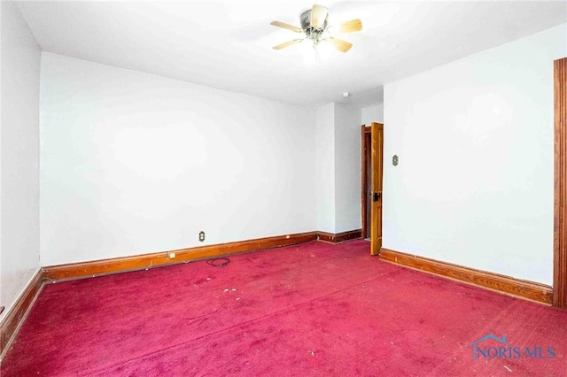 empty room featuring ceiling fan and carpet