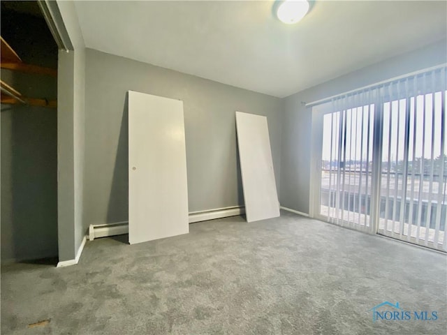 unfurnished bedroom featuring a baseboard heating unit and carpet