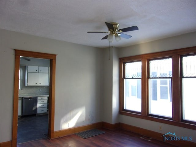 empty room with ceiling fan and dark hardwood / wood-style flooring