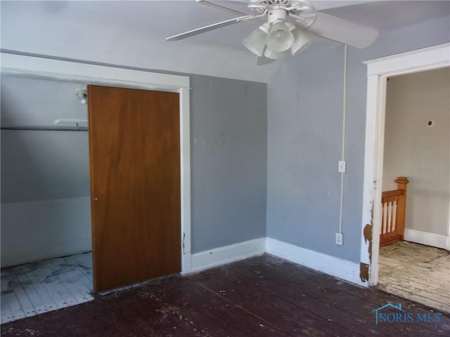 unfurnished bedroom with ceiling fan, a closet, dark wood-type flooring, and lofted ceiling