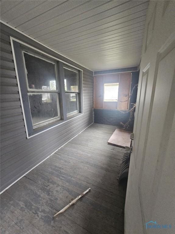 interior space featuring hardwood / wood-style flooring and wooden walls