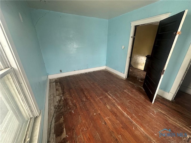 unfurnished bedroom featuring dark wood-type flooring and a closet