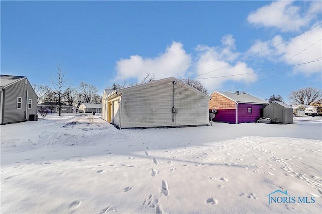 snow covered property with an outdoor structure