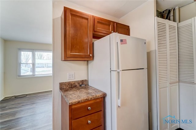 kitchen featuring wood-type flooring and white refrigerator