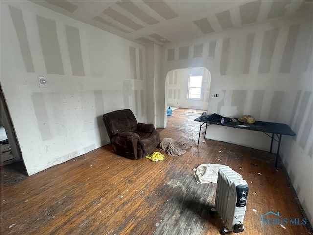 living area featuring dark hardwood / wood-style floors and radiator heating unit