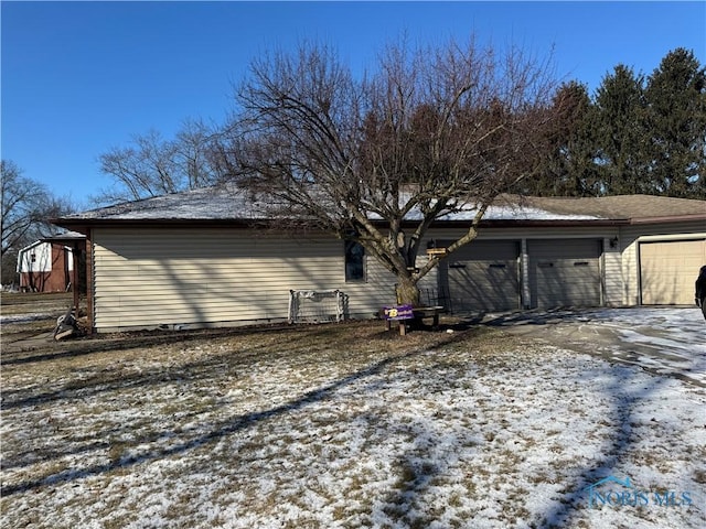 snow covered property featuring a garage