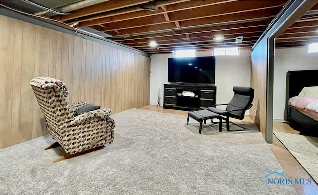 sitting room featuring carpet and wood walls