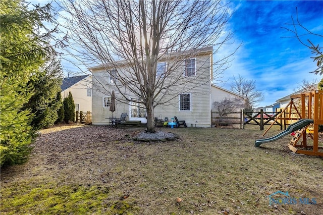 back of property featuring a playground and a yard