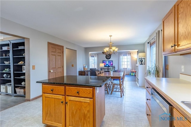 kitchen featuring hanging light fixtures, a center island, stainless steel dishwasher, a notable chandelier, and light tile patterned floors