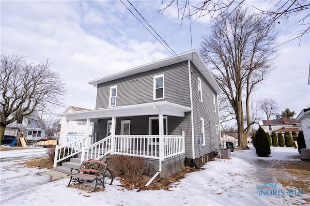 traditional style home with covered porch and central AC unit