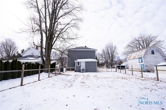 snowy yard with a shed, an outdoor structure, and fence