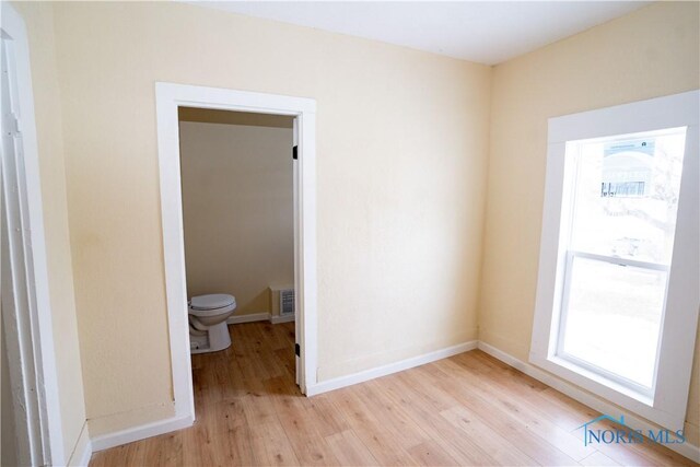 interior space with light wood-style flooring, visible vents, and baseboards