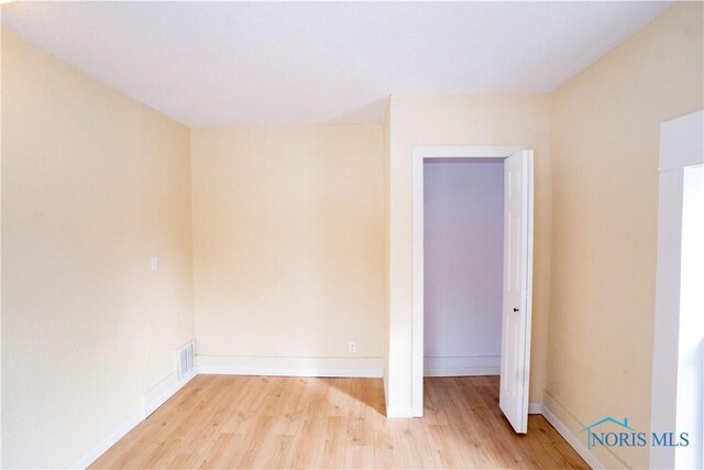 spare room with visible vents, light wood-style flooring, and baseboards