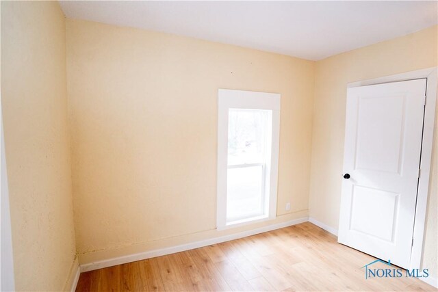 spare room featuring light wood finished floors and baseboards