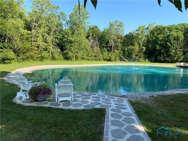 view of pool featuring a yard and a water view