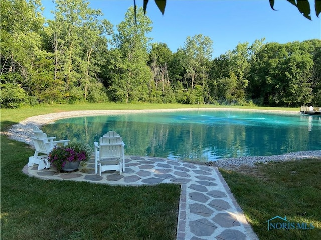 view of pool featuring a yard and a water view