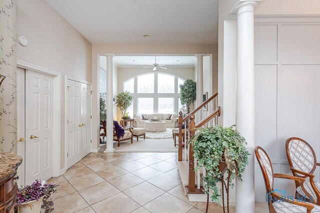 tiled entryway featuring decorative columns and ceiling fan