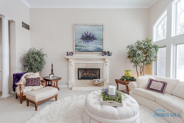 carpeted living room with ornamental molding, a high end fireplace, and ornate columns