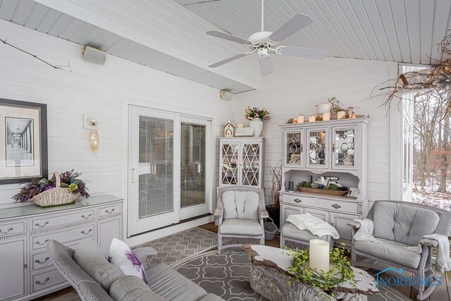 living room featuring ceiling fan, wooden ceiling, and wooden walls