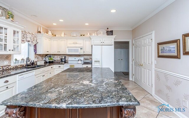 kitchen featuring sink, white cabinetry, light tile patterned floors, white appliances, and a kitchen island