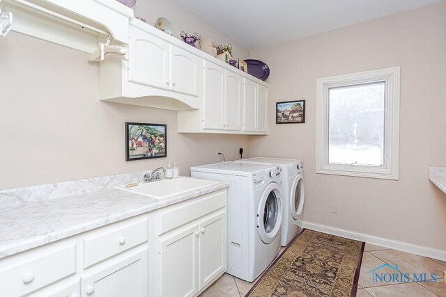 clothes washing area featuring sink, light tile patterned floors, cabinets, and independent washer and dryer