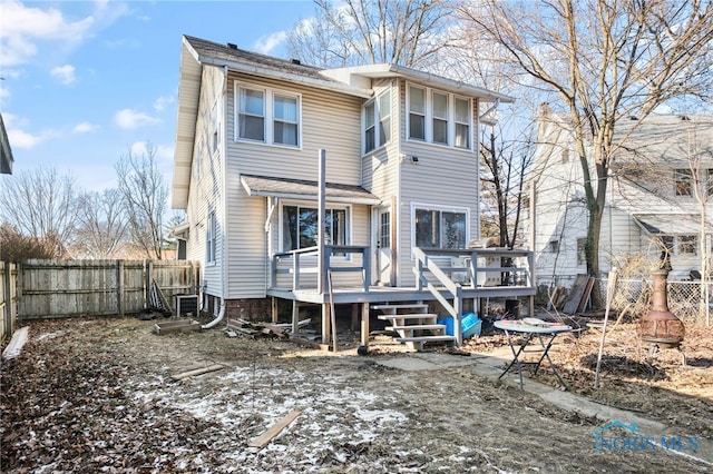 back of property with a fenced backyard and a wooden deck