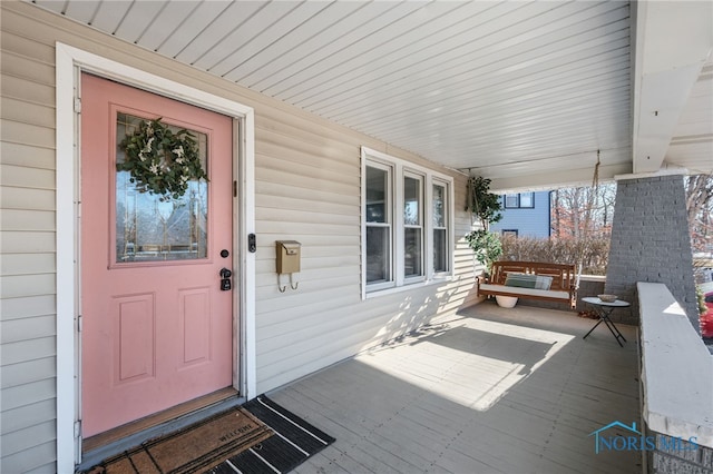 view of exterior entry featuring covered porch