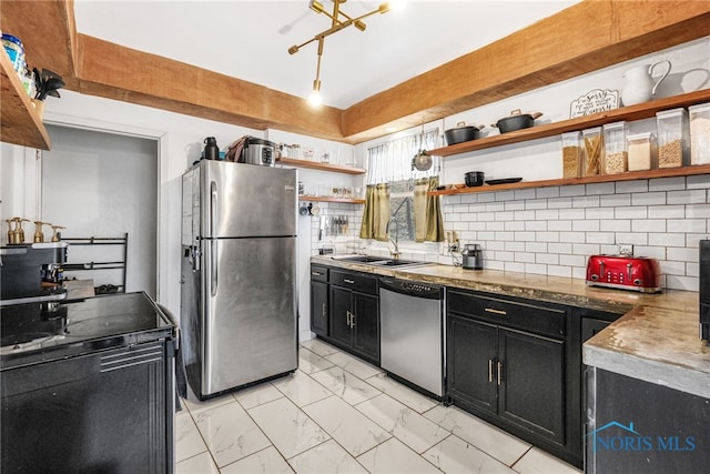 kitchen featuring marble finish floor, open shelves, appliances with stainless steel finishes, a sink, and dark cabinets