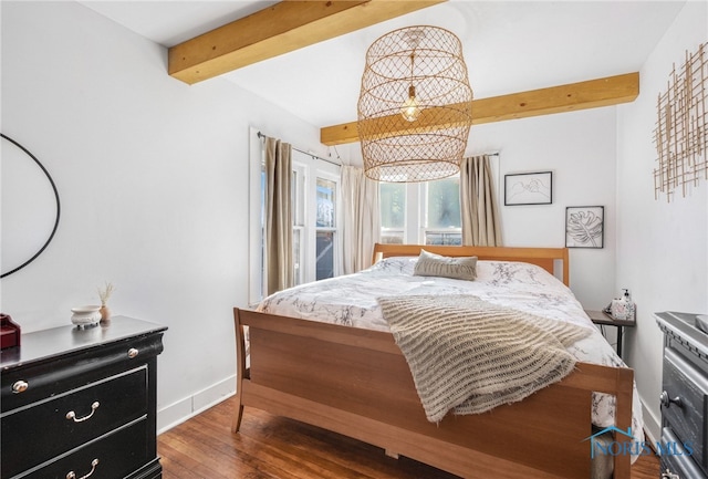 bedroom with wood finished floors, beam ceiling, and baseboards